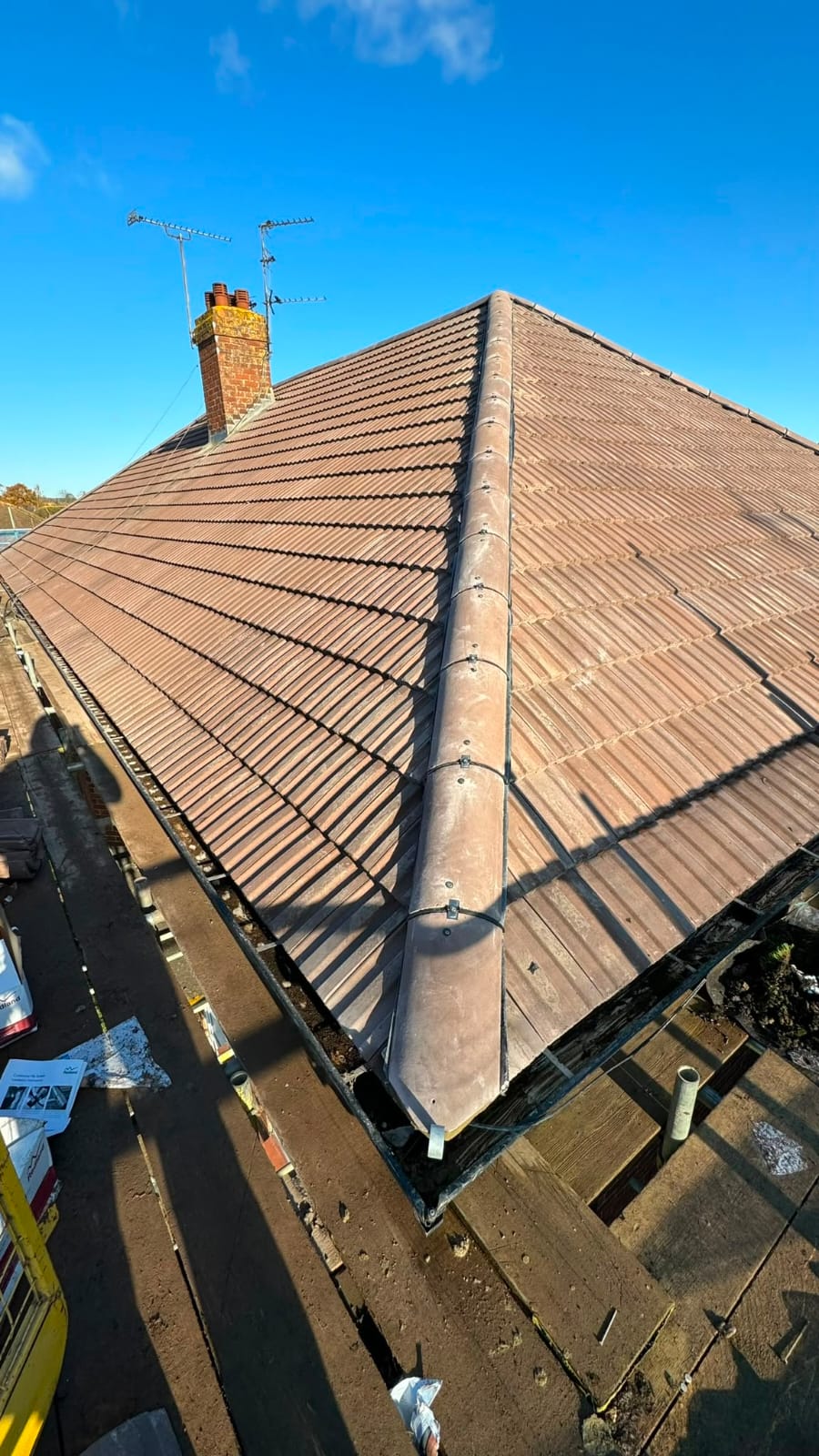 Newly finished hipped tiled roof with brick chimney stack