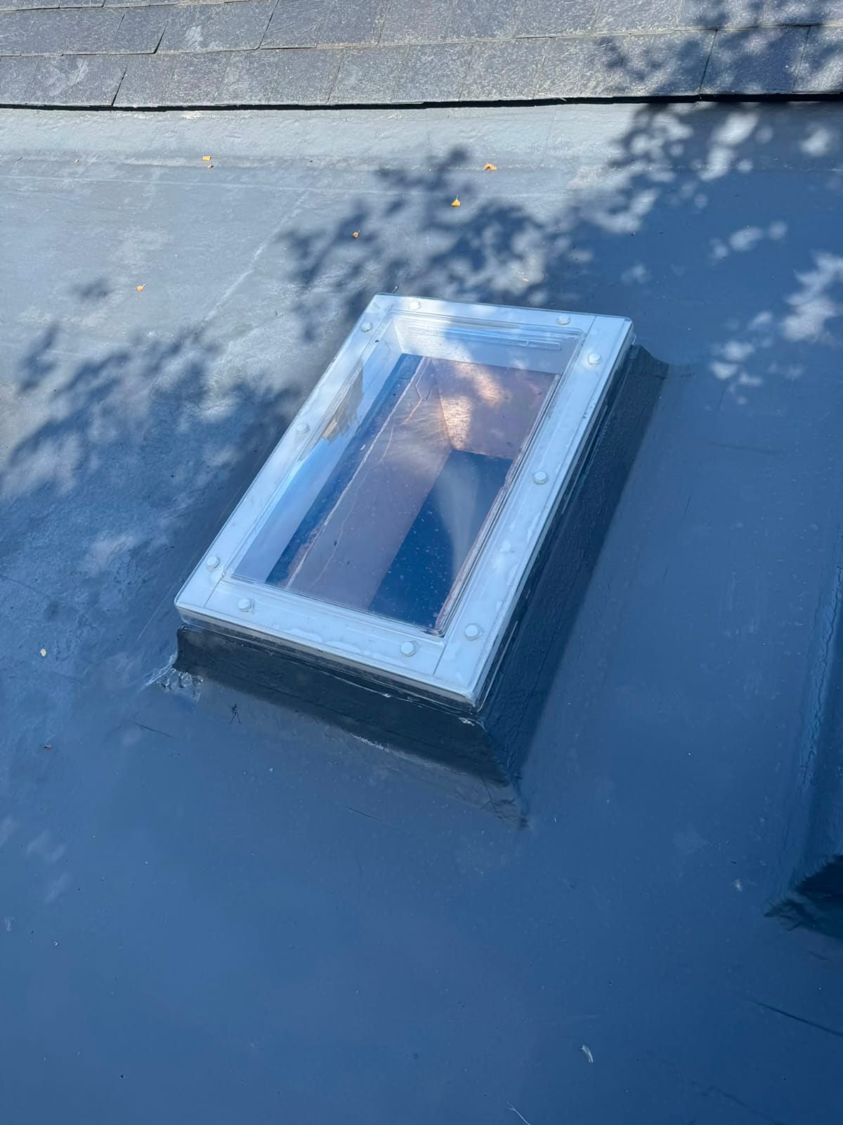 Velux skylight window fitted and weathered into a grey flat roof